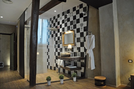 Interno della camera con travi in legno e bagno a vista
