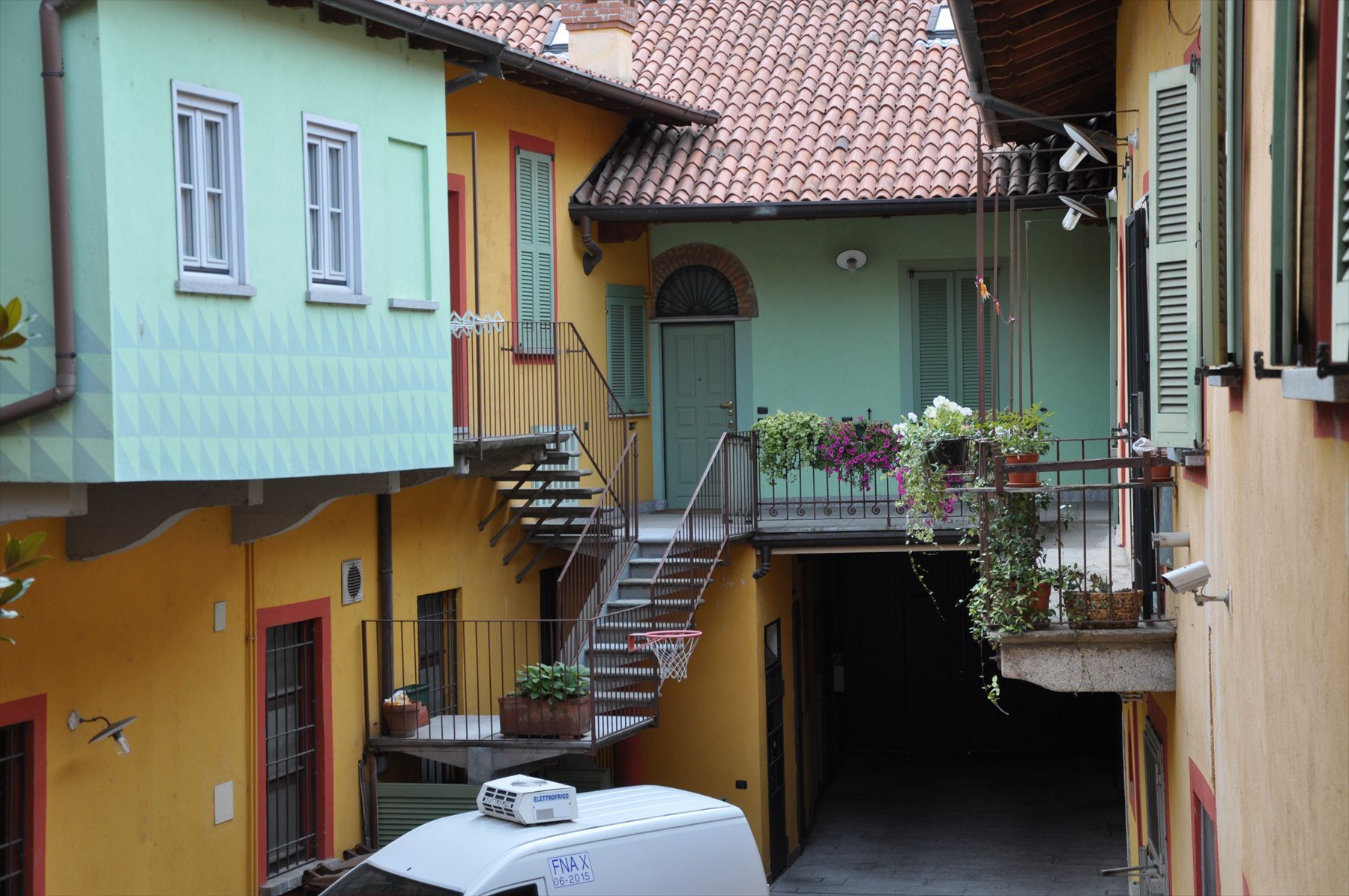 Cortile storico con facciate colorate e balconi fioriti