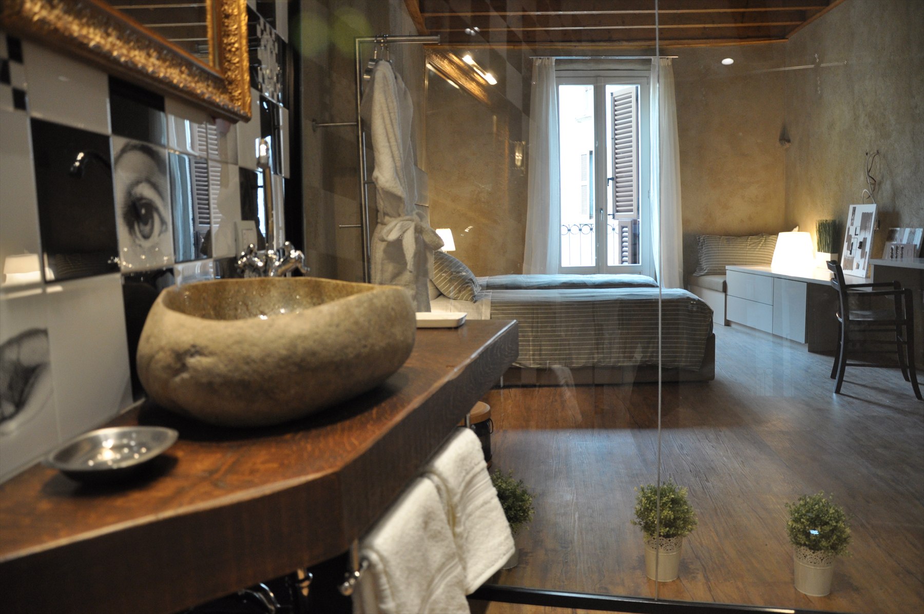Vista completa della camera e del bagno con lavabo in pietra